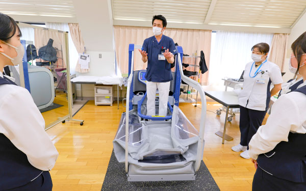 現場でリハビリ器具の説明をする理学療法士