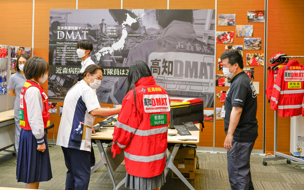 DMAT説明コーナーで物品や隊服の説明をするスタッフ